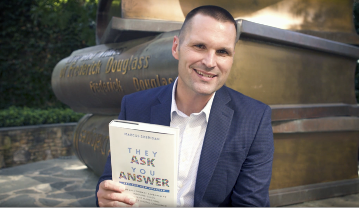 Marcus Sheridan with the book and business framework he wrote - They Ask, You Answer